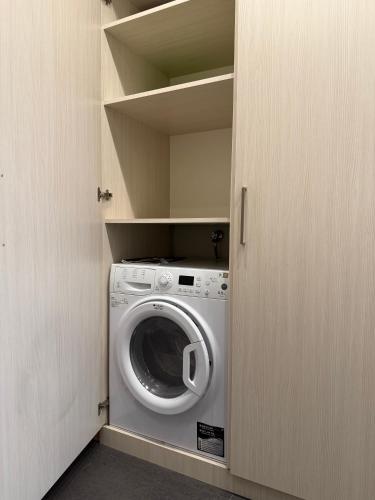 a laundry room with a washing machine in a closet at Sweet Home Apart-Hotel in Yerevan