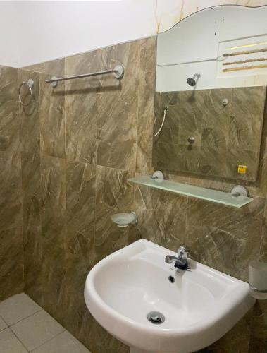 a bathroom with a sink and a mirror at Araliya Self Cooking Resort Dambulla in Dambulla