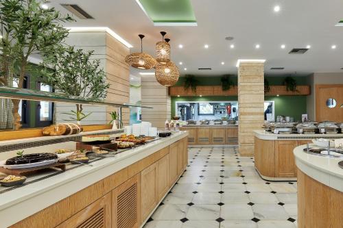 a large kitchen with a buffet line with food at Sentido Kyknos Beach Adults Only in Malia