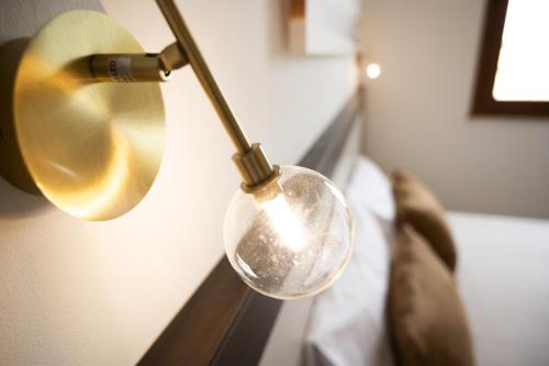 a silver spoon hanging from a lamp on a wall at Easylife - a 2 passi dal mare Sant'Isidoro in Sant'Isidoro