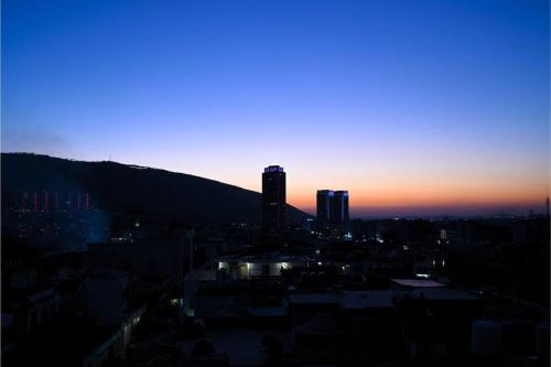 a view of a city at sunset at Coral Hotel in Duhok