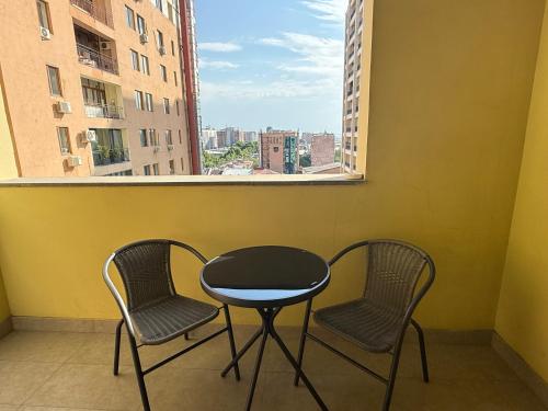 two chairs and a table on a balcony with a window at Sweet Home Apart-Hotel in Yerevan