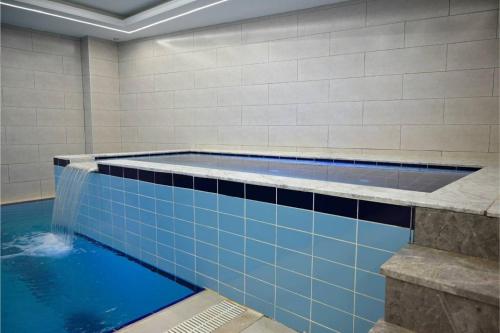 a swimming pool with a water feature in a bathroom at Coral Hotel in Duhok