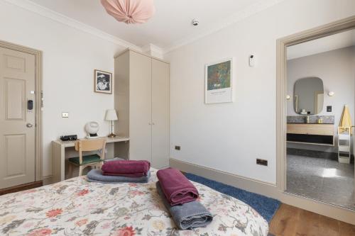 a bedroom with a bed with two pillows on it at Royal Greenwich Hospitality in London