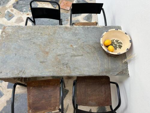 a table with chairs and a bowl of lemons on it at Pé na Terra Quintal in Reguengos de Monsaraz