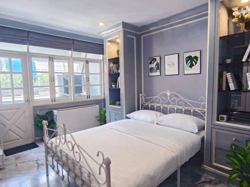 ein Schlafzimmer mit einem weißen Bett und blauen Wänden in der Unterkunft Cozy Private Family Apartment in Bangkok CBD Silom-Sathorn - 240m to BTS Saint Louis in Yan Nawa