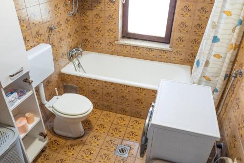 a bathroom with a toilet and a tub and a sink at Orle Nature Retreat in Škofljica
