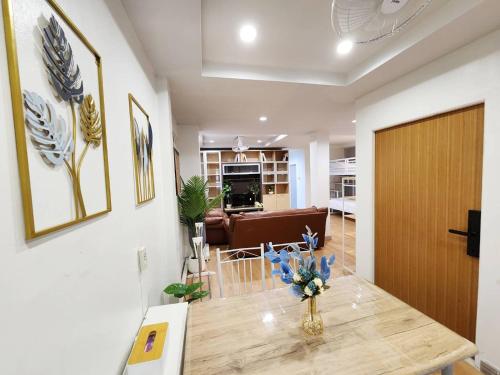 ein Wohnzimmer mit einem Tisch und einer Blumenvase darauf in der Unterkunft Cozy Private Family Apartment in Bangkok CBD Silom-Sathorn - 240m to BTS Saint Louis in Yan Nawa