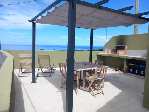 a patio with a table and chairs under a canopy at Alto do Sossego in Nordeste
