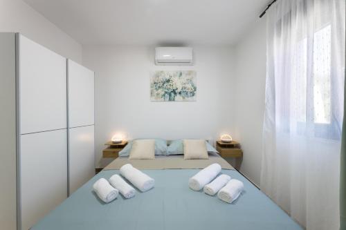 a white room with a bed with white pillows at Villa Bijaći in Kastel Novi