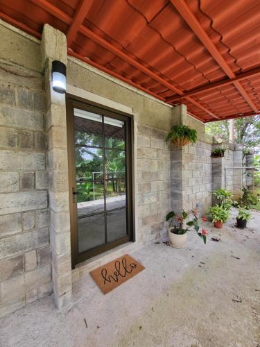 a porch with a glass door on a brick wall at Casa del Cafe-Familiar in Heredia