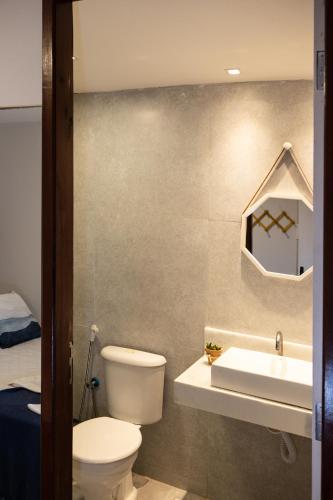 a bathroom with a toilet and a sink at Pousada Makai in Porto De Galinhas