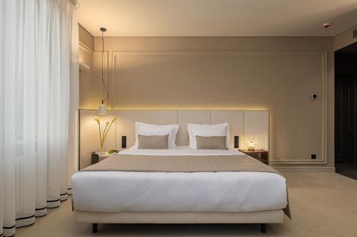 a bedroom with a large white bed with two pillows at LUBICH Concept Hotel in Lviv