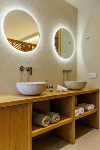 dos lavabos en una encimera en un baño con dos espejos en Limnonari Garden room, en Skopelos Town