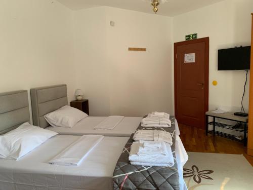 two beds in a room with a television and a room with at Diplomat Haven in Sremska Kamenica