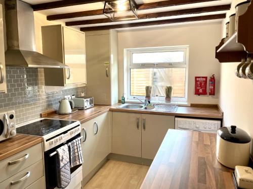 eine Küche mit Spüle und Herd in der Unterkunft Miners cottage(1840)Nr. Brecon,Tower Zip & Bike Pk in Aberdare