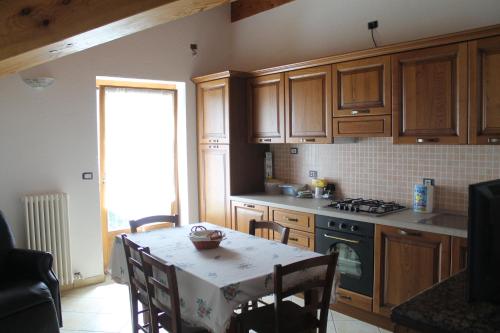 una cucina con armadi in legno e un tavolo con una tovaglia di Appartamento Pommier a Saint-Pierre