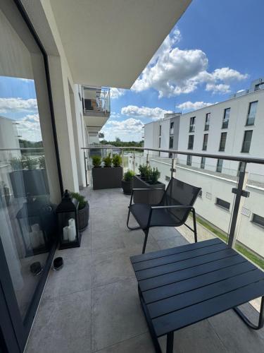 a balcony with a bench and chairs on a building at MERLIN Apartments in Zamość