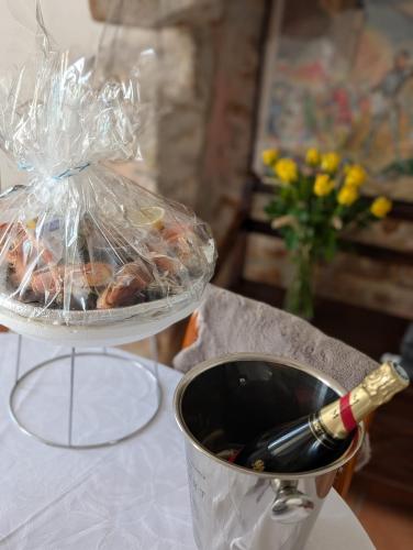 un récipient de nourriture et une bouteille de vin sur une table dans l'établissement Chez Adèle, au Mont-Saint-Michel