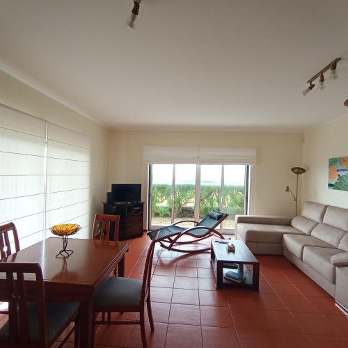 a living room with a couch and a table at Casa dos Salgueiros in Faja Grande