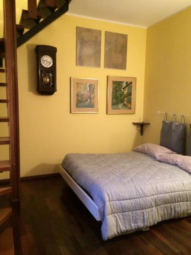a bedroom with a bed and a clock on the wall at Oasi La Francoise in Rozzano