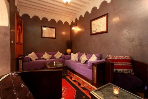 a living room with a purple couch and a table at Riad Khalid Zrika Marrakech in Marrakesh