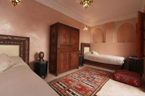 ein Schlafzimmer mit zwei Betten und einem Teppich in der Unterkunft Riad Khalid Zrika Marrakech in Marrakesch