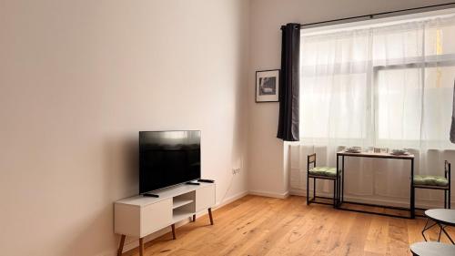 een woonkamer met een flatscreen-tv aan de muur bij Central premium apartment in München