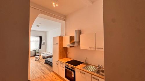 een keuken met witte kasten en een woonkamer bij Central premium apartment in München