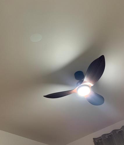a ceiling fan with a light on a ceiling at Diplomat Haven in Sremska Kamenica