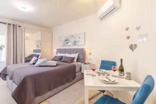 a bedroom with a bed and a table with wine glasses at eVita Fazana Premium Studio Apartments in Fažana