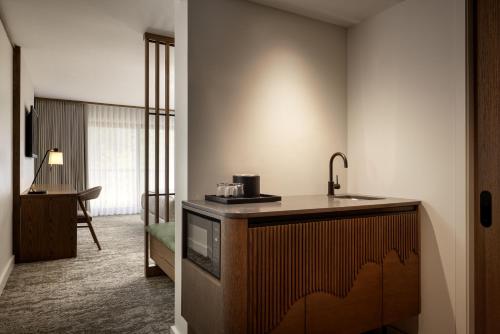 a hotel room with a television and a sink at Banff Park Lodge in Banff
