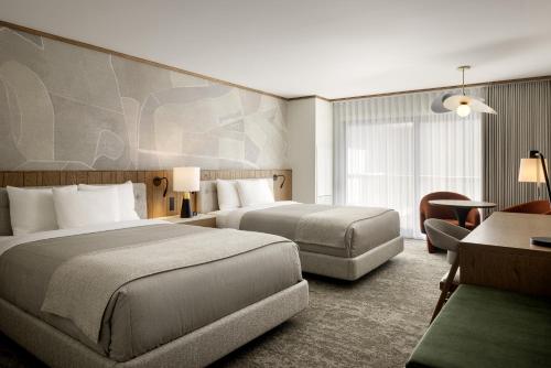 a hotel room with two beds and a desk at Banff Park Lodge in Banff