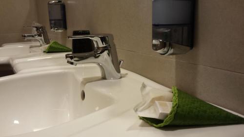 a white bathroom sink with a green tissue at Life Sport Hotel in Mentana