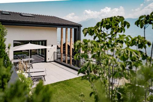 a house with a balcony with a table and benches at Hillepranter in Marlengo