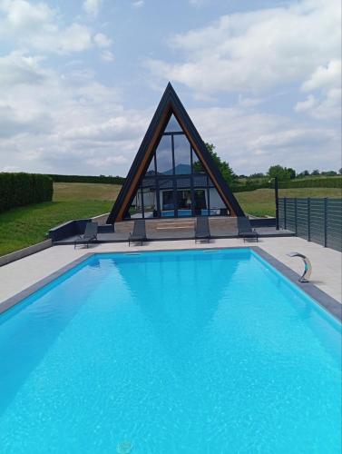 a swimming pool with a pyramid shaped building at Villa Rustic in Majetići