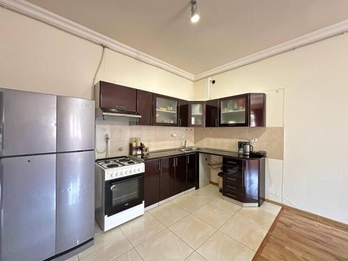 une grande cuisine avec des armoires et des appareils électroménagers marron dans l'établissement Avan House, à Erevan