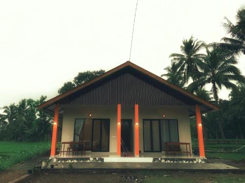 a small building with orange pillars in front of it at Green House Tetebatu in Tetebatu