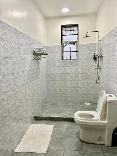 a bathroom with a toilet and a shower at Luxury And Spacious Pool house near the beaches in Diani Beach