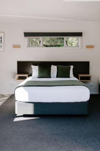 a bedroom with a large bed and a window at Te Mata Views Resort in Havelock North