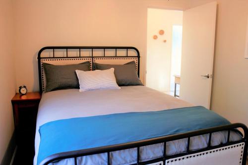 a bedroom with a bed with a blue blanket at Elegant Carmel Cottage in Carmel