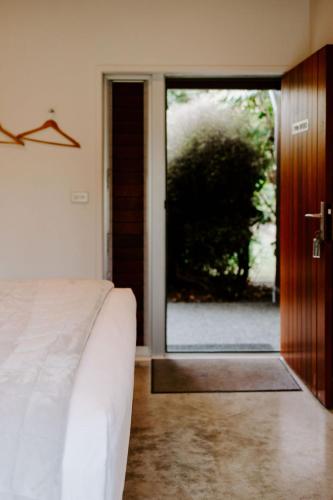 a bedroom with a bed and a sliding glass door at Te Mata Views Resort in Havelock North