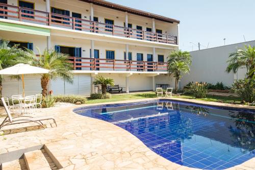 a hotel with a swimming pool in front of a building at Pousada Dona Emilia in Brotas
