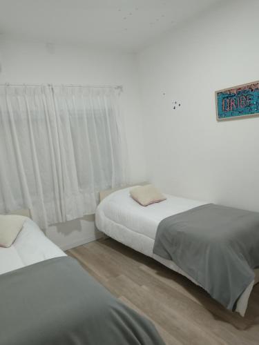 Un dormitorio con dos camas y un cartel en la pared. en Bello atardecer Uribe, en Uribelarrea