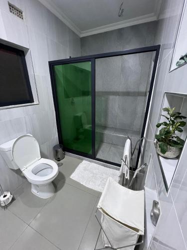 a bathroom with a toilet and a glass shower at 1 bed apartment with pool & gym in Mpemba
