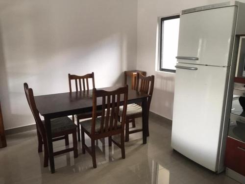 a kitchen with a table and chairs and a refrigerator at 1 bed apartment with pool & gym in Mpemba