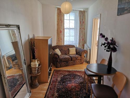 a living room with a couch and a mirror at Flat next to port and cliffs with parking in Dover