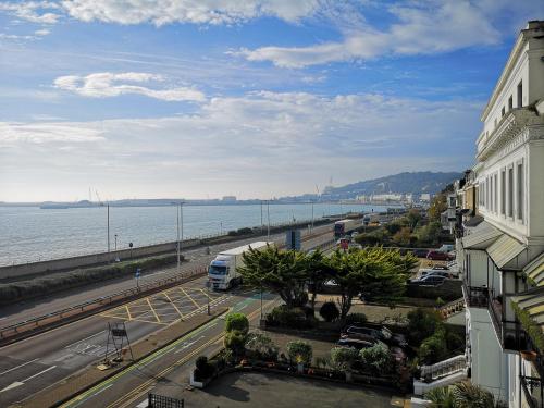 a bus is parked in a parking lot next to the water at Flat next to port and cliffs with parking in Dover