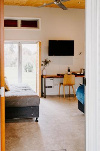 a bedroom with a bed and a desk with a television at Te Mata Views Resort in Havelock North