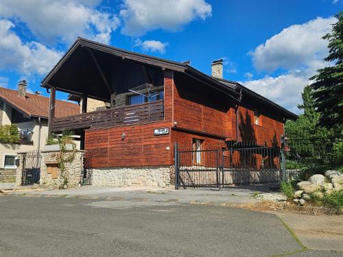 a large wooden building with a black roof at Wellness Toliar Tatry in Stará Lesná